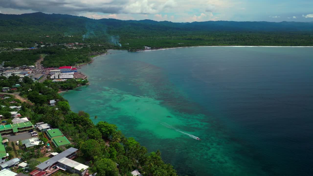 Power boat canoe driving Wewak costal town Dogreto Bay aerial drone Wewak Hill Papua New Guinea PNG East Sepik Region Province Boram road summer sunny morning dry season Bismark Sea backwards