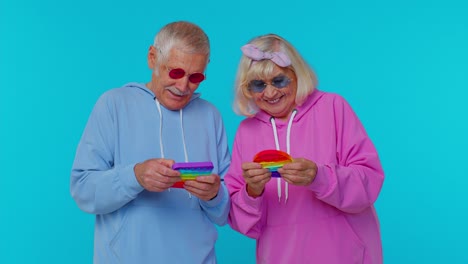 anciana abuela feliz abuelo jugando a apretar anti-estrés empujar pop es un juego de juguete popular