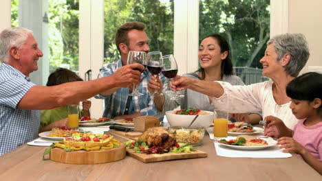 familia de varias generaciones almorzando y brindando con vino