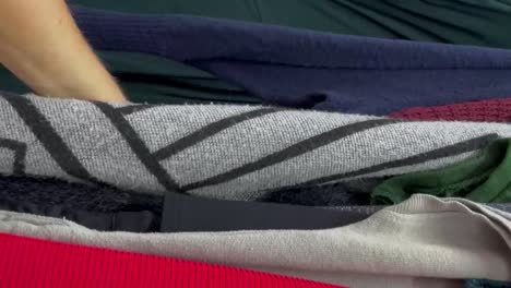 close-up of a woman inspecting second-hand clothes. buying used clothes.