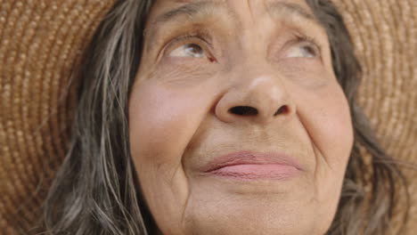 close up portrait of elderly indian woman smiling enjoying outdoor garden feeling calm peaceful wearing hat