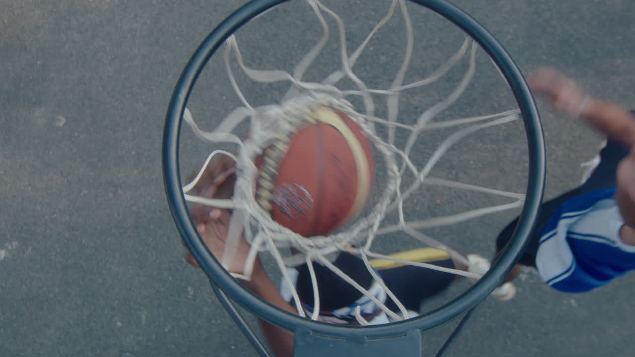 Black Guy Shooting Basketball Through the Hoop on Outdoor Playground