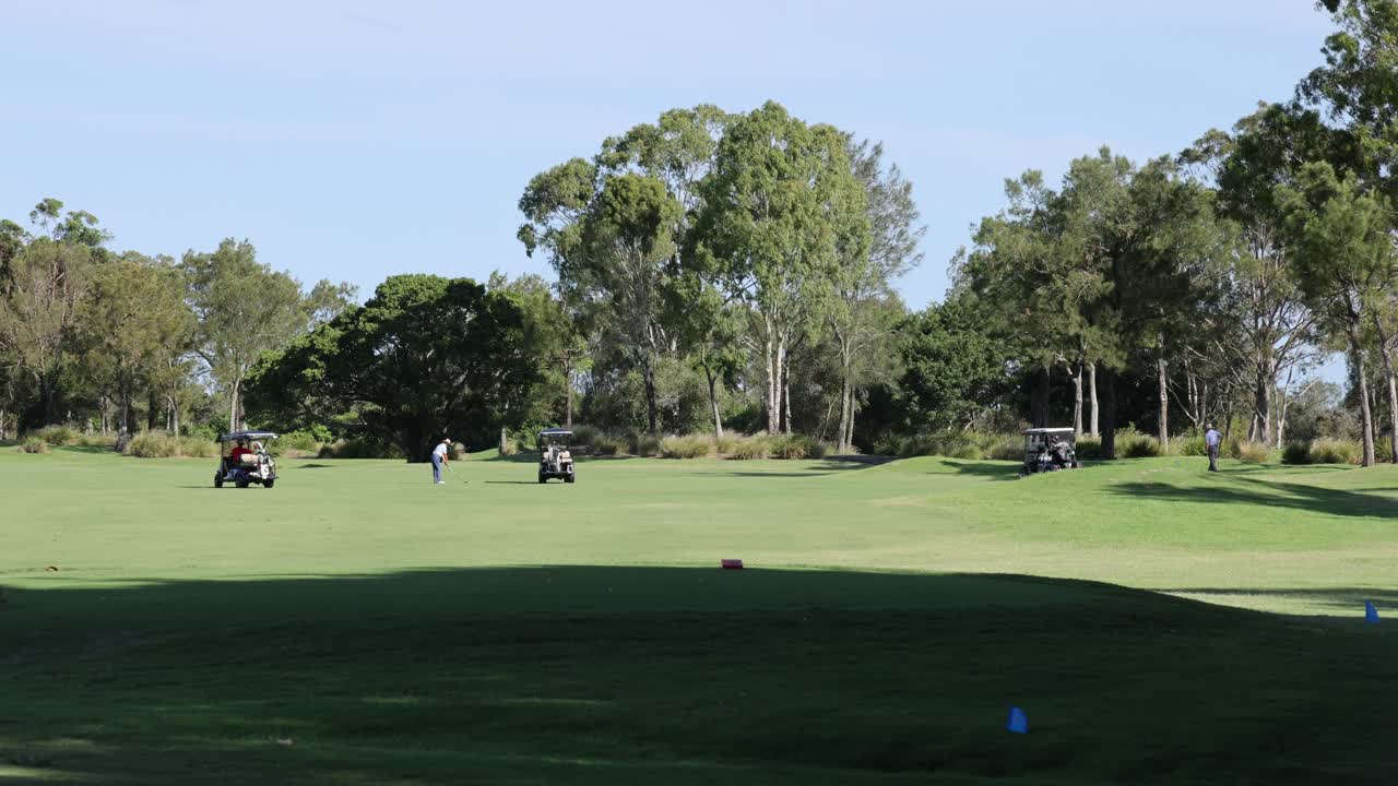 울창 한 초록색 코스 를 가로질러 이동 하는 골프 카트