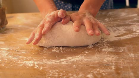 Manos-Femeninas-Amasando-Una-Bola-De-Masa-Sobre-Una-Superficie-Harinosa