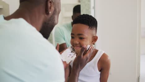 African-american-father-putting-shaving-cream-on-his-son-mouth-and-laughing-together