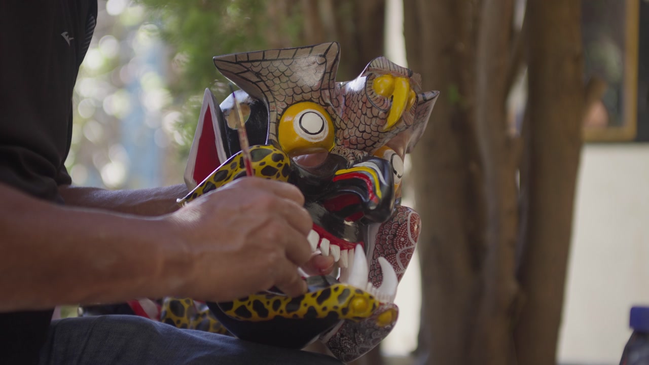 SLOW MOTION CLOSE UP SHOT OF A MAN PAINTING A MEXICAN MASK