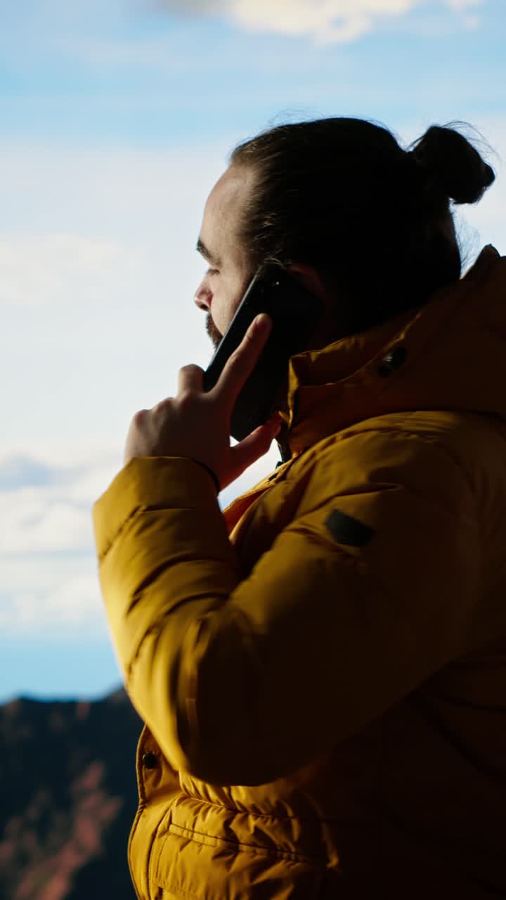 Young Man Talking on Mobile Phone with Mountain View