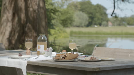 delicious breakfast set up on table in the countryside near pond - medium