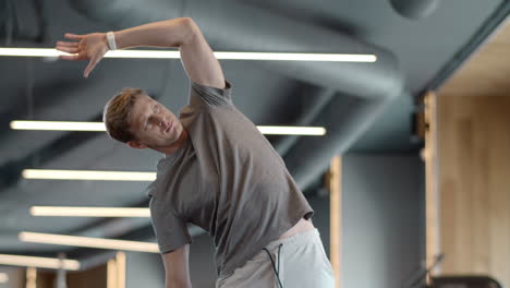 Serious-athlete-man-warming-up-at-gym.-Sportsman-doing-exercises-in-sport-club