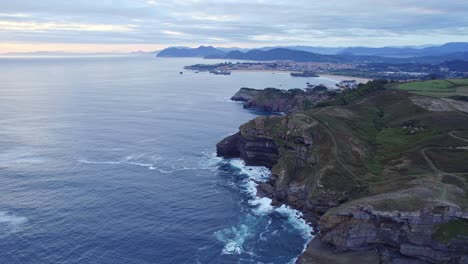 drone capture the green island of isla, cantabria from the great height on cloudy day