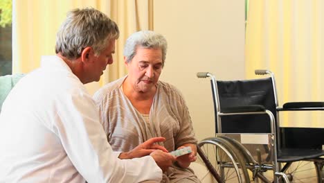 médico dando pastillas e instrucciones a su paciente