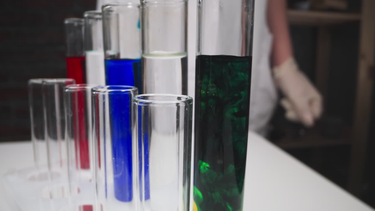 goteo de reactivo en el tubo de ensayo bajo el control de un asistente de laboratorio