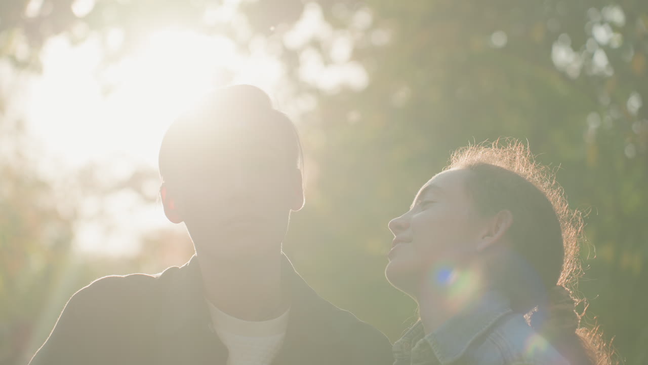 温かい太陽の光を浴びるカップル。愛情深い恋人たちが穏やかな幸福を分かち合う、陽光に包まれた瞬間を捉えている。輝く太陽の下で二人の恋人が穏やかで優しい時間を楽しむ、輝かしい情景。