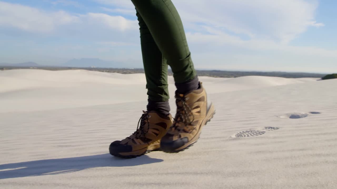 mujer con zapatos deportivos caminando en el desierto 4k