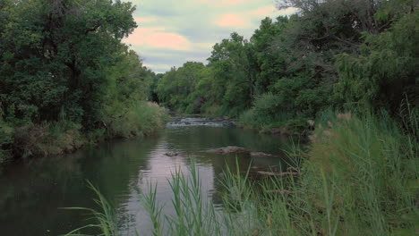 Forward-flying-low-angle-aerial-shot-in-breathtaking-peaceful-and-calming-river-scene