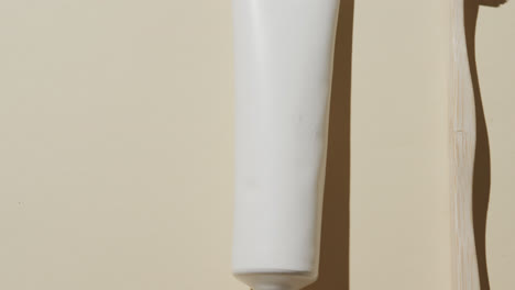 close up of toothbrush and toothpaste on beige background with copy space