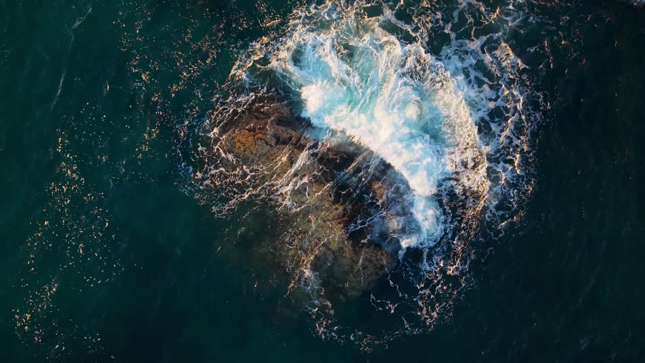 Waves crashing around a rocky formation in genoa, liguria, italy, aerial view