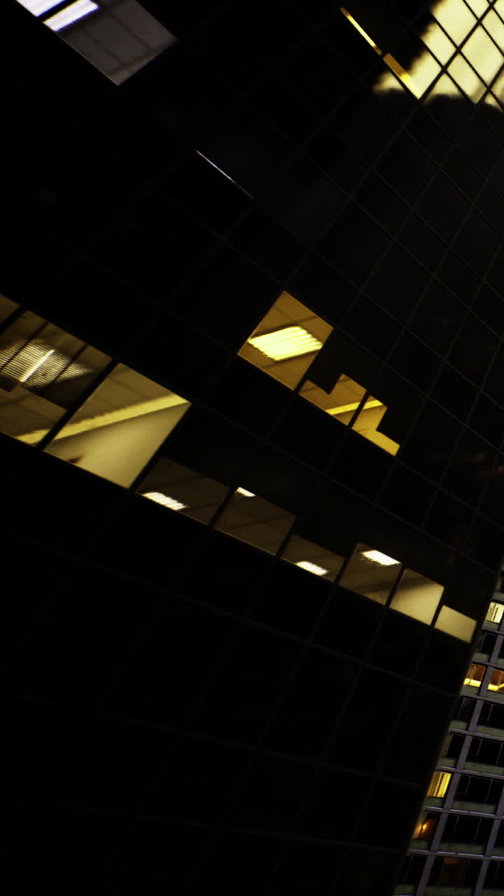 Edificio scuro con finestre illuminate di notte in un ambiente urbano
