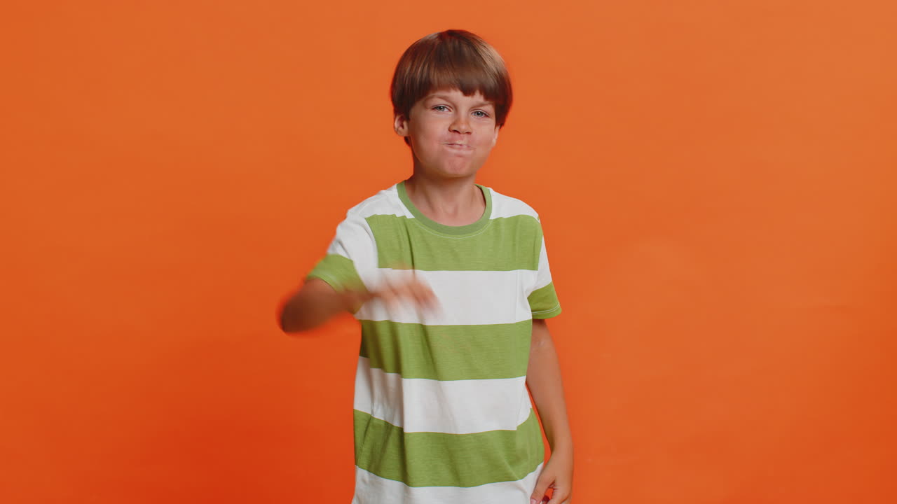 Frightened child boy closing mouth with hands refusing to tell terrible secret unbelievable truth