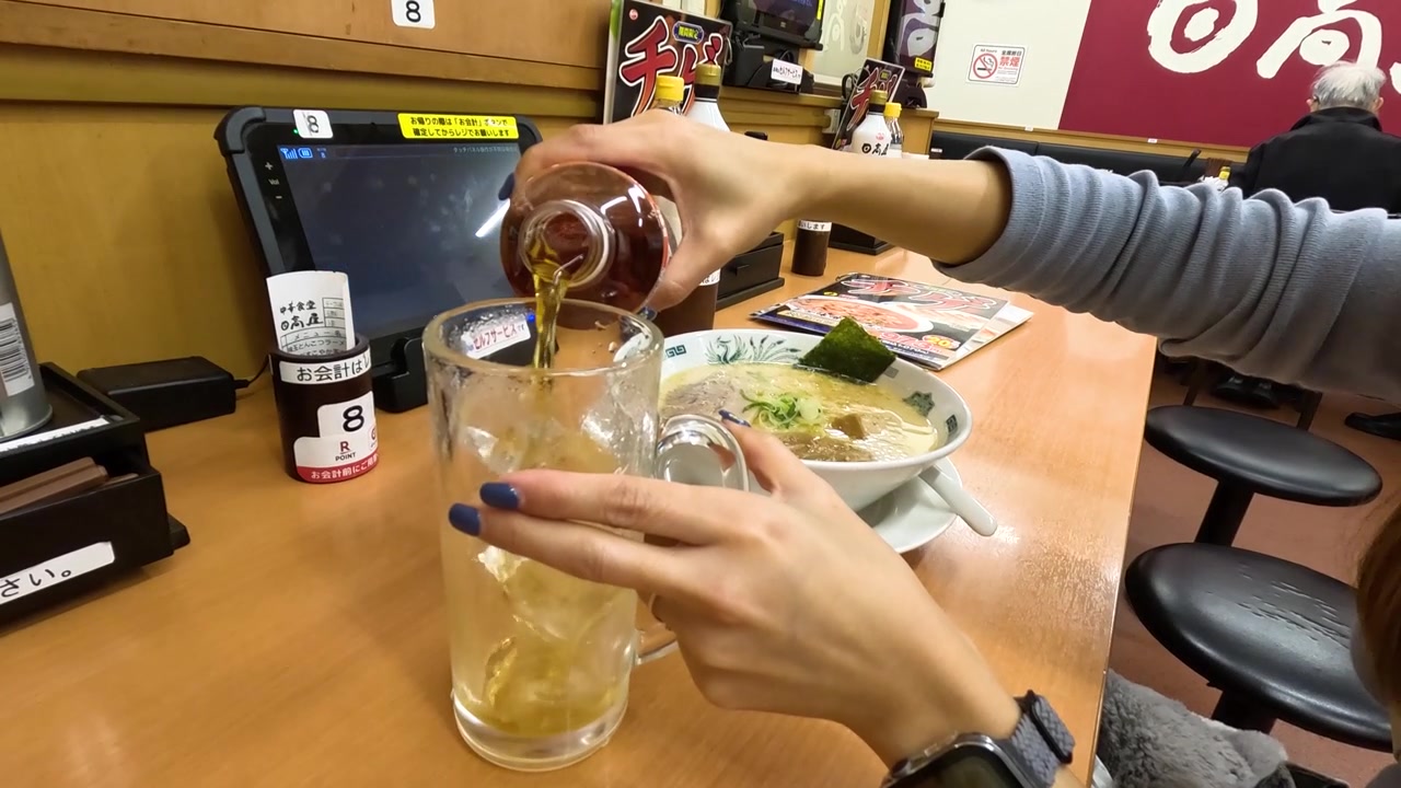 Cận cảnh đôi tay đang rót trà vào ly có đá tại một nhà hàng ở Tokyo