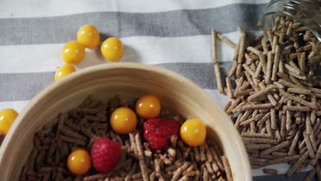 Bowl-of-cereal-bran-stick-with-golden-berries-and-raspberries-4k