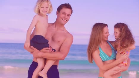 pareja caucásica llevando a su hijo e hija a la playa