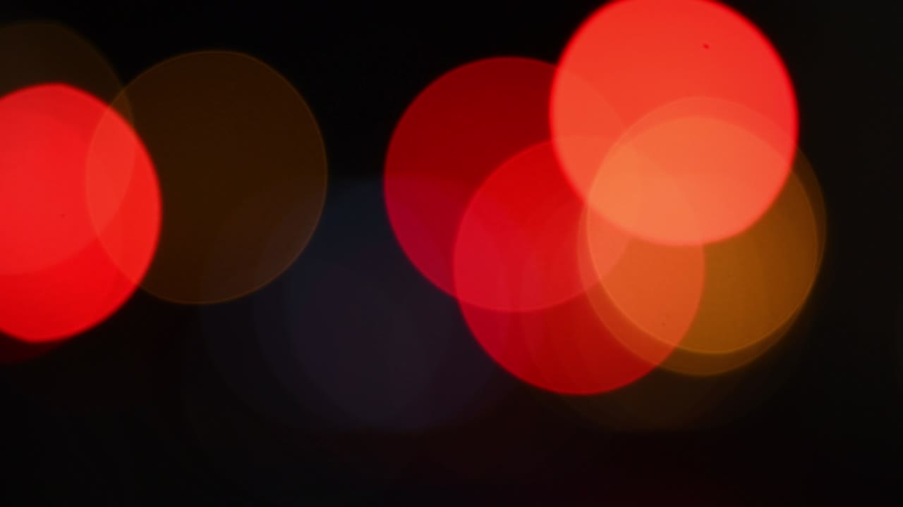 colores rojos y naranjas brillantes luces bokeh parpadeando en la oscuridad de la noche