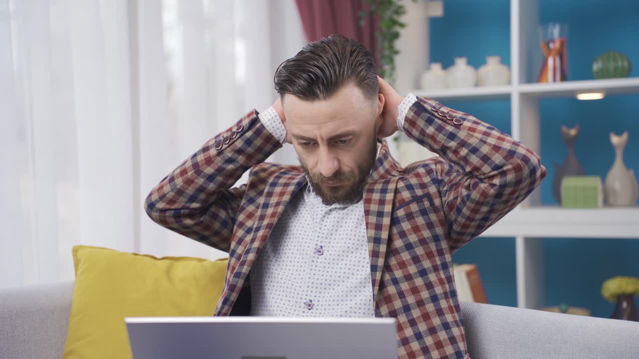 hombre usando computadora portátil enojado, frustrado, recibiendo malas noticias en casa.