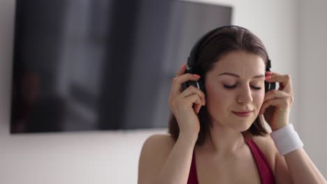 woman putting on music in headphones and starting warmup