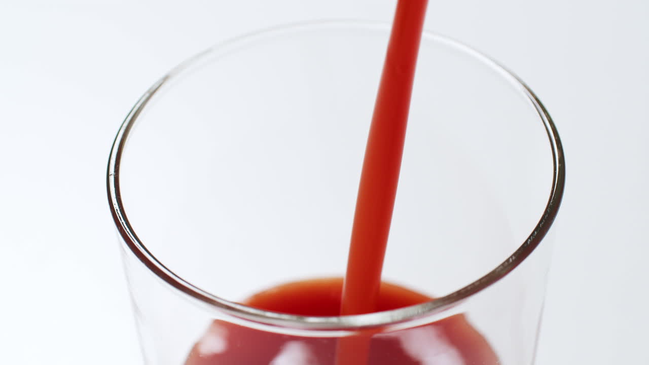 한 잔 을 상쾌 한 차가운 토마토 주스 로 채우고, 그 주스 가 가장자리 까지 거품 을  ⁇ 고, 그 중 일부 를 잔 의 측면 에 떨어뜨리는 것