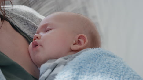 bebé durmiendo pacíficamente en los brazos de la madre madre amorosa sosteniendo al bebé cuidando al bebé dormido en casa 4k