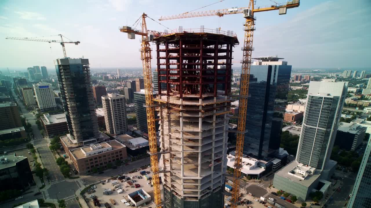 Drone camera moving closer cranes lifting steel framing crown growing advancing construction