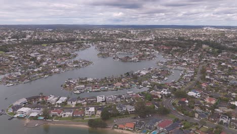 stunning bird’s-eye aerial footage flying over luxurious waterfront homes in sylvania waters, sydney, australia, showcasing beautiful residential properties and serene coastal views.
