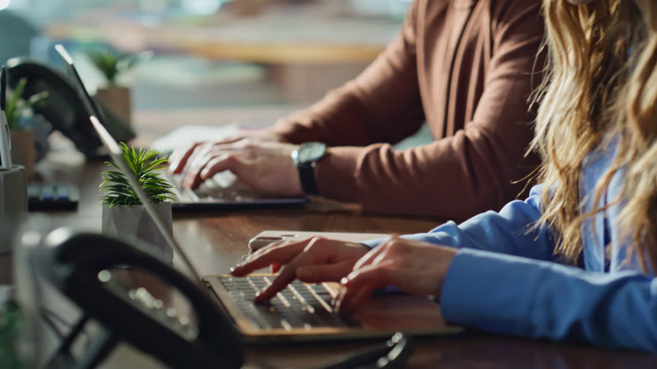 Office managers working online at laptops in corporate workplace closeup