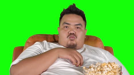 fat man enjoying popcorn on the sofa
