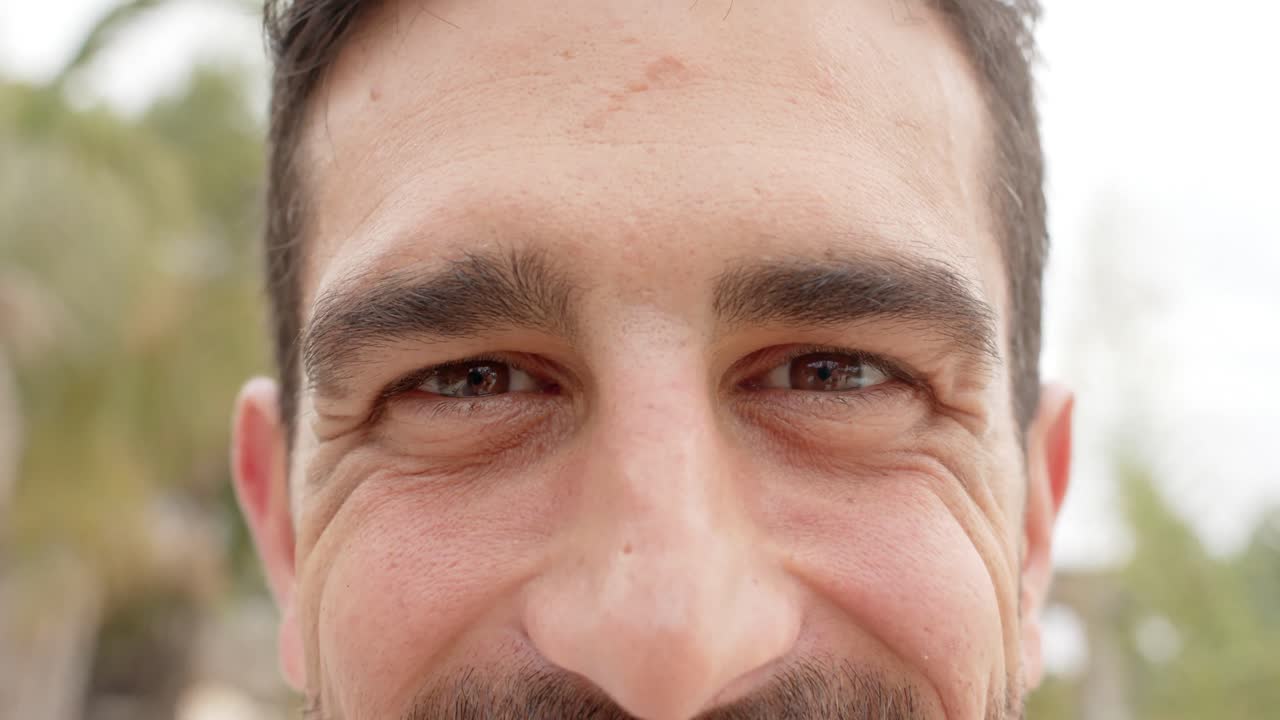 retrato de un hombre caucásico feliz mirando a la cámara sobre la playa