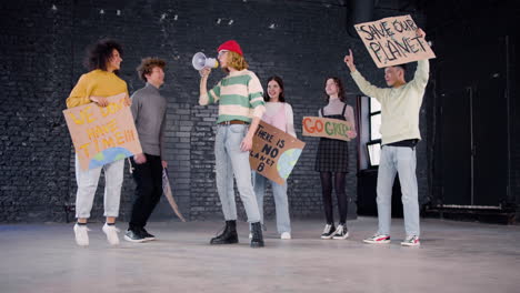 happy young environmental activists with placards and megaphone jumping and protesting against climate change inaction