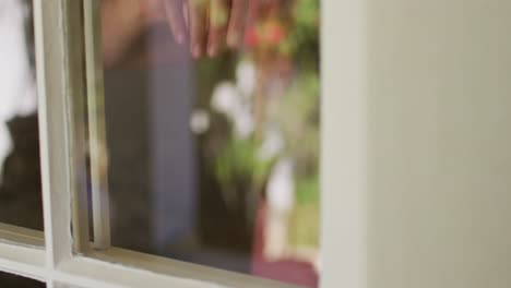 Mujer-Caucásica-Con-Mascarilla-Mirando-Por-La-Ventana-En-Casa