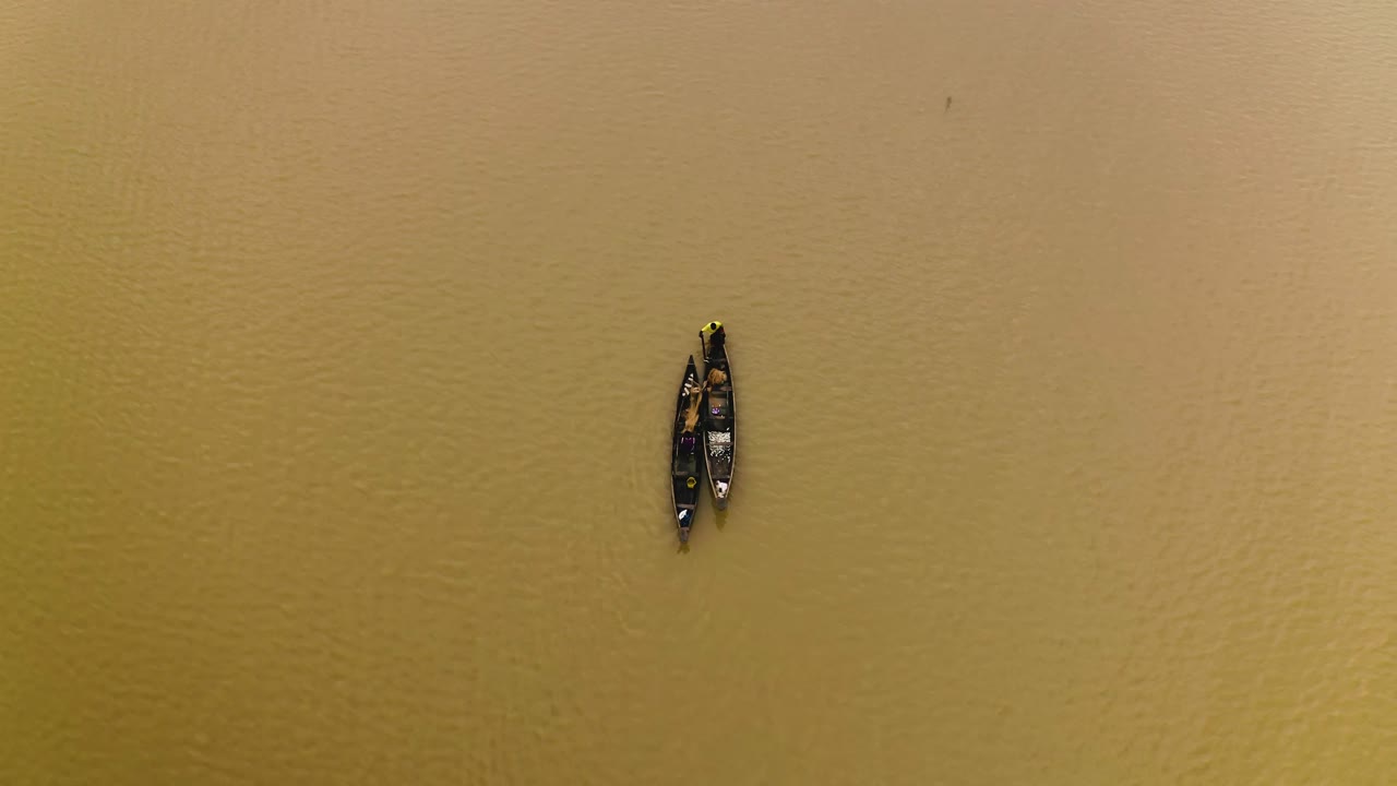 pescadores navegando en un lago en sus canoas