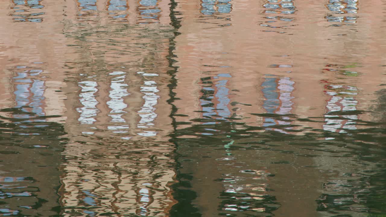 Rippling canal water reflects historic architecture, soft daylight, and gentle movement in Nuremberg, Germany