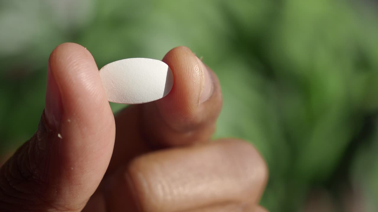 색 약을 들고 있는 손의 클로즈업