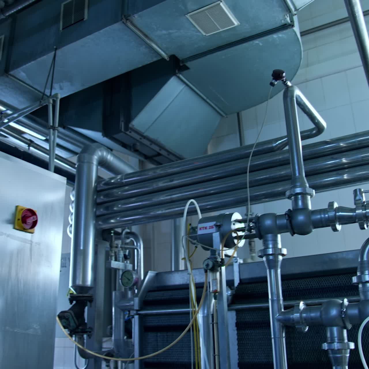 Silver stainless pipelines at a dairy factory. Tubes and pipes of different diameter and controller box in the modern milk enterprise. Close up