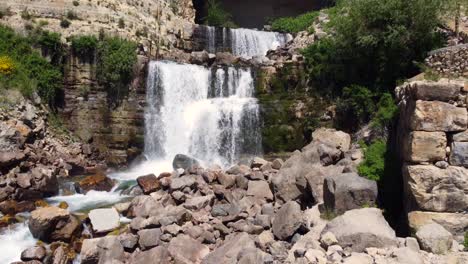 Tourist-Walking-By-Rocky-Path-Overlooking-Afqa-Waterfall-In-Lebanon---aerial-shot