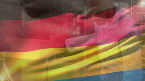 animation of german flag over biracial engineer looking at blueprint of design