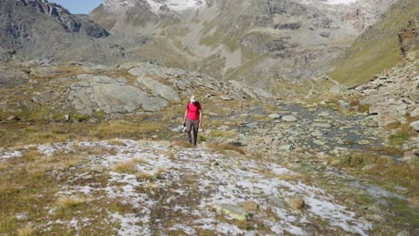 Tourist-hikes-with-camera-through-fall-mountain-landscape