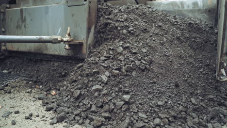 process of pouring hot asphalt out off the heavy machine into the ground. roadworks repaving process. close-up
