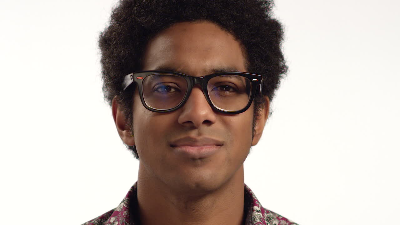 CU Young Man Cracks a Smile at Camera