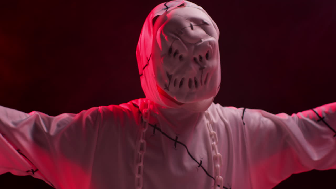 유령, 좀비, 괴물 의상을 입은 아이가 할로윈에 사람들을 겁내며 은 연기 배경에 대항합니다.