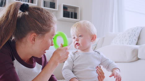 young mum playing with her toddler son at home, close up