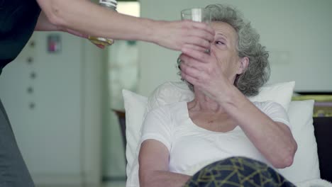 daughter coming to mothers bed, giving pills and glass of water